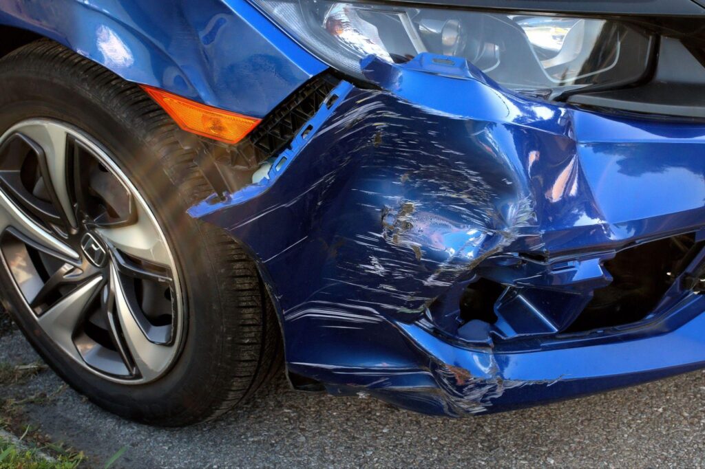 Blue car with a smashed front bumper