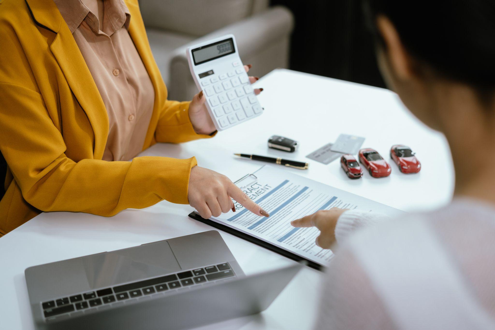 Woman signing car dealer insurance document in Oklahoma